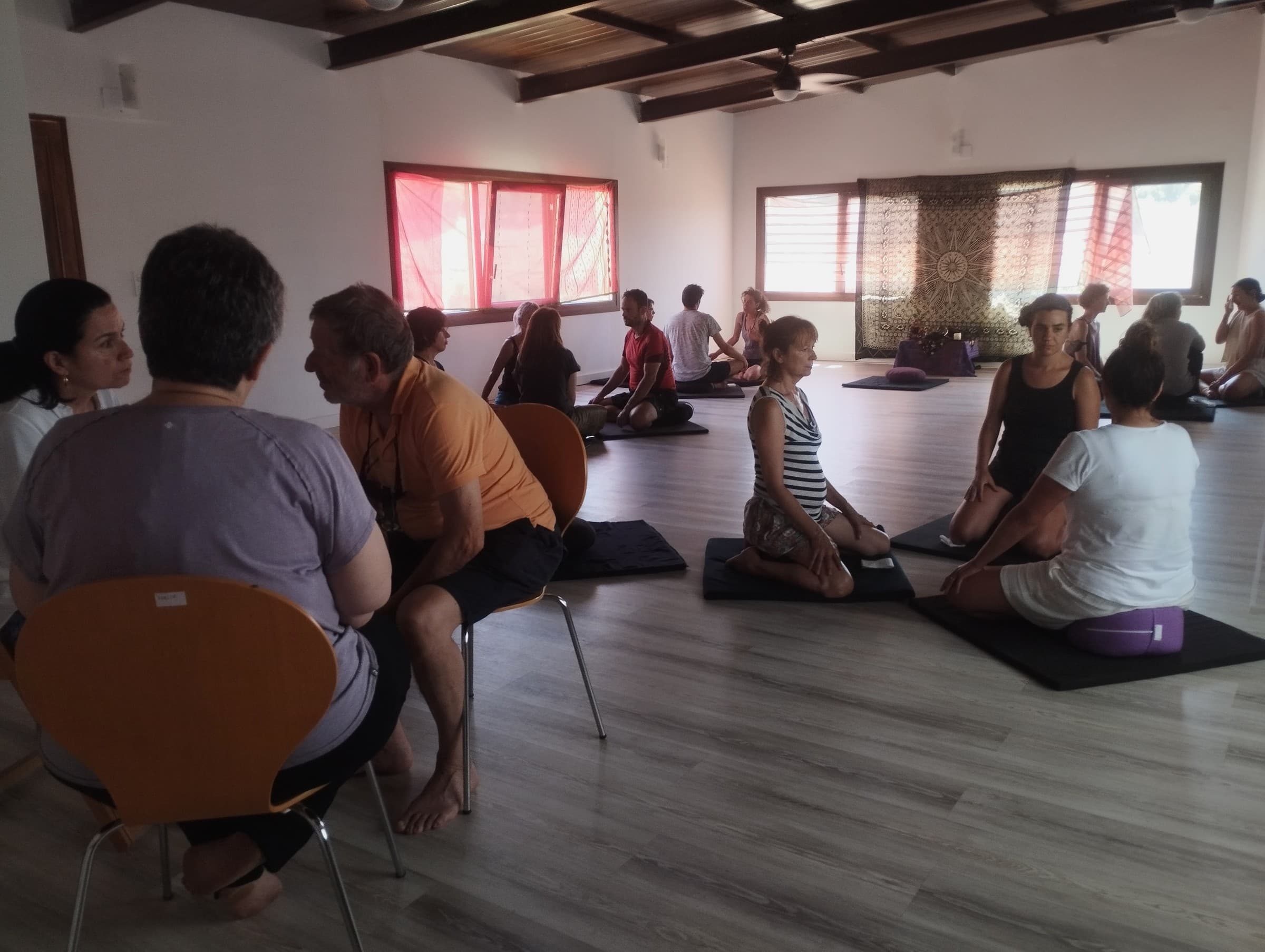 Participantes comparten una práctica de escucha por parejas en una sala de retiro.