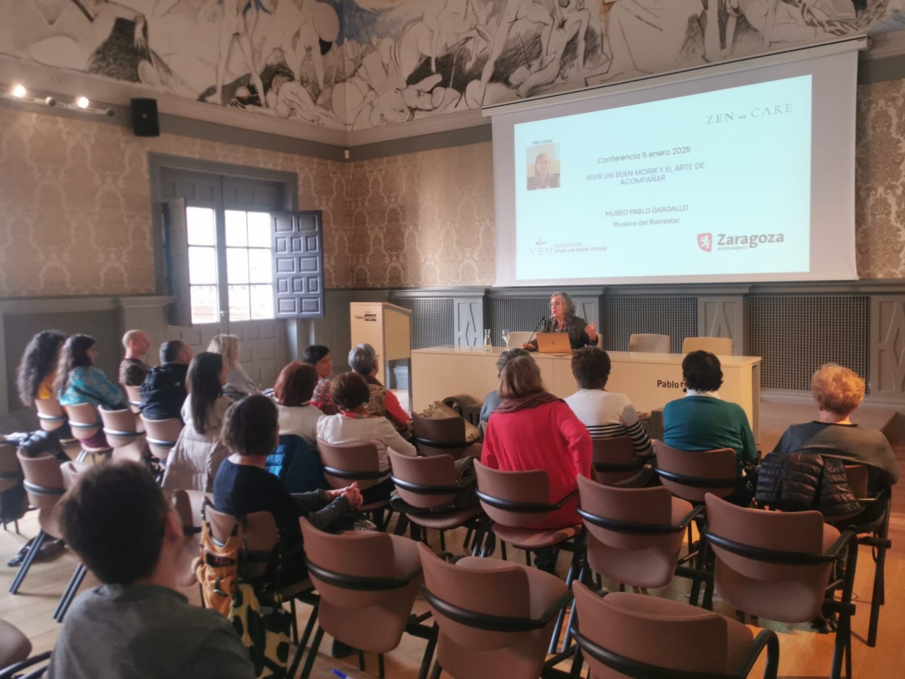 Mar López presenta una conferencia ante un público en el Museo Pablo Gargallo.